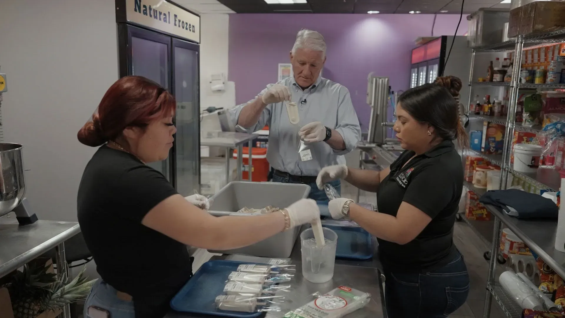 نساء يعملن في متجر لبيع الآيس كريم والفواكه المكسيكية في براونزفيل، مع التركيز على تأثير الانتخابات على الأعمال الصغيرة.