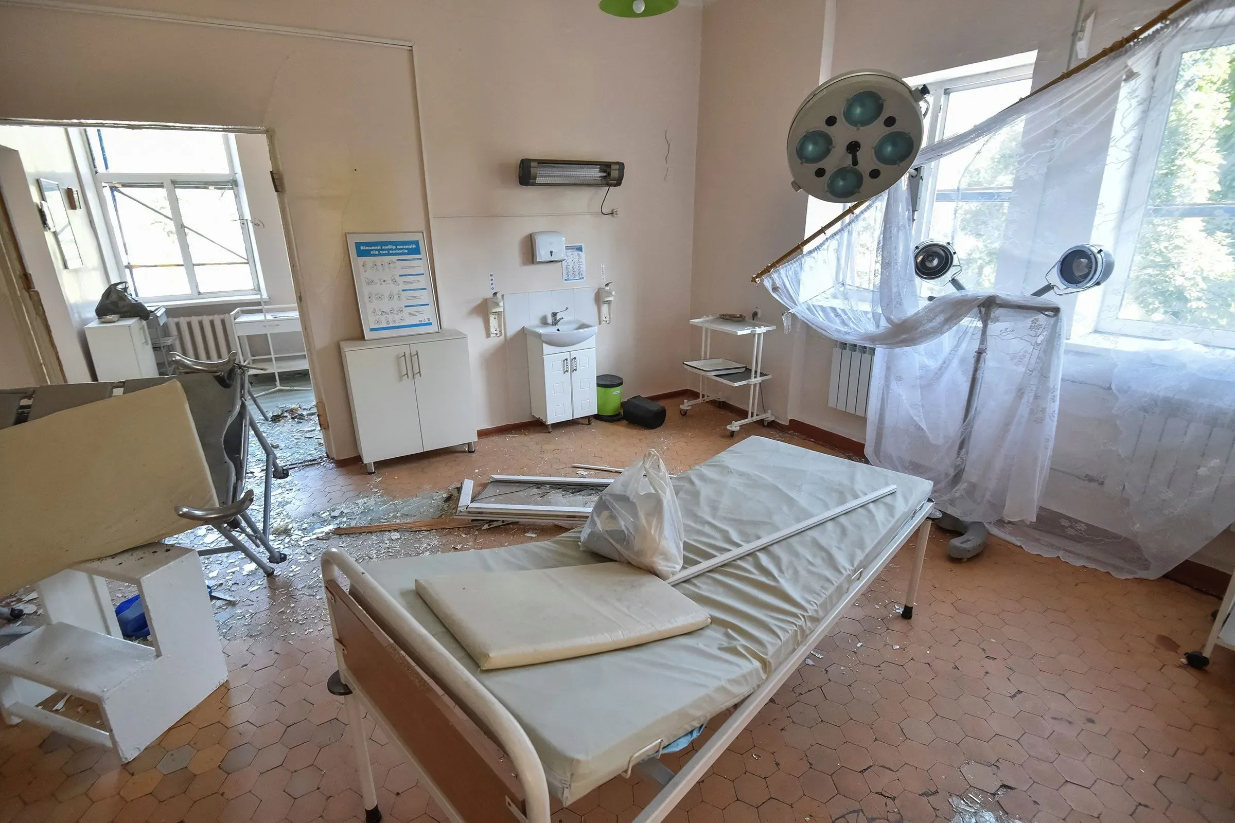 غرفة ولادة في مستشفى كاميانسكي بعد الهجوم، تظهر الأثاث المكسور والزجاج المتناثر، مما يعكس الدمار الناتج عن الصاروخ الروسي.