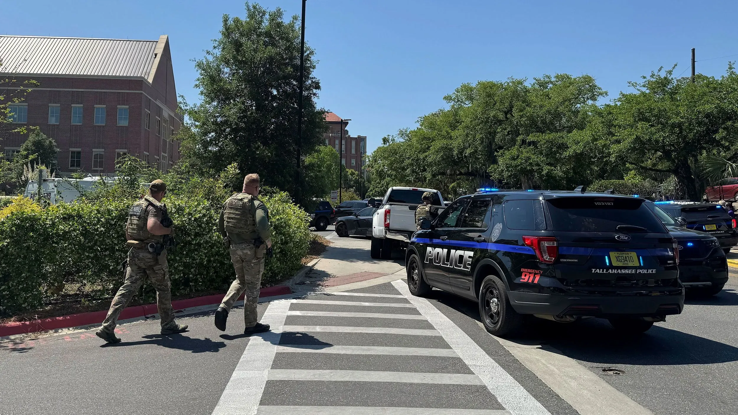 انتشار الشرطة في حرم جامعة ولاية فلوريدا بعد حادث إطلاق نار، حيث يظهر ضباط يرتدون زيًا عسكريًا بالقرب من سيارات الشرطة.