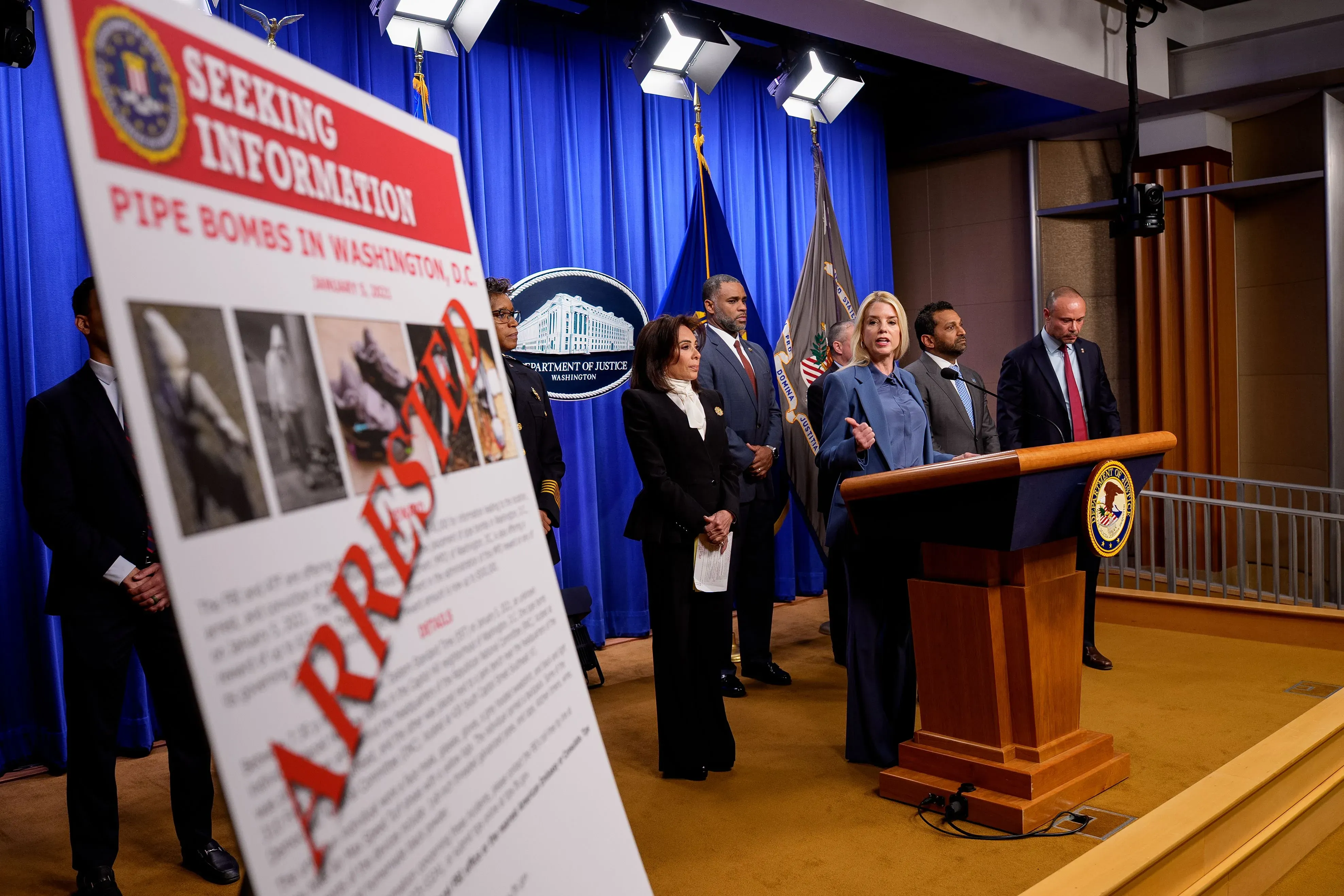 مؤتمر صحفي لوزارة العدل حول قنابل أنبوبية في واشنطن، مع مسؤولين يتحدثون عن الاعتقالات والتحقيقات المتعلقة بأحداث 6 يناير.