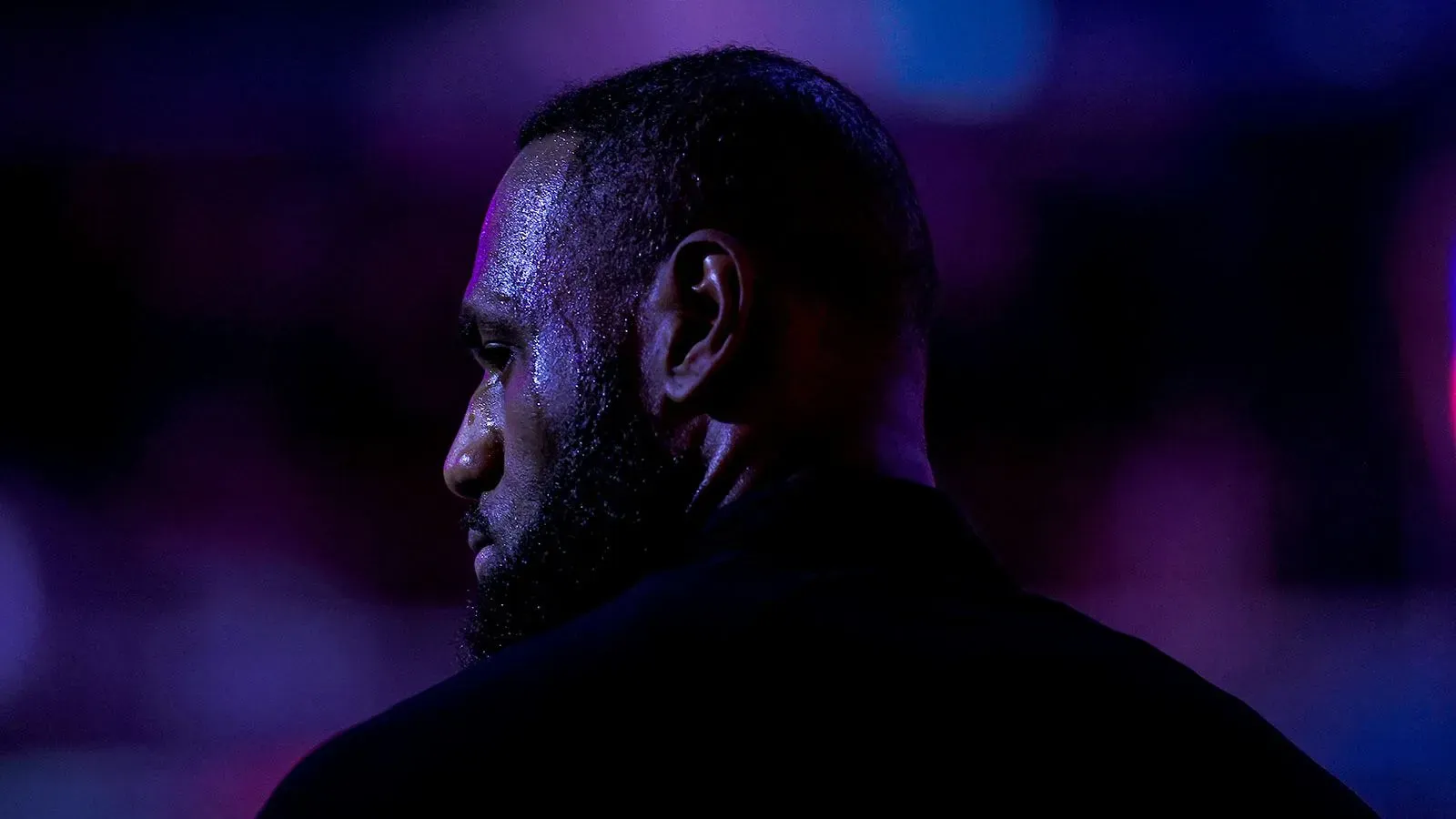 يظهر ليبرون جيمس من الخلف في أضواء خافتة، مما يعكس تفكيره حول مستقبله في الدوري الأمريكي للمحترفين مع لوس أنجلوس ليكرز.