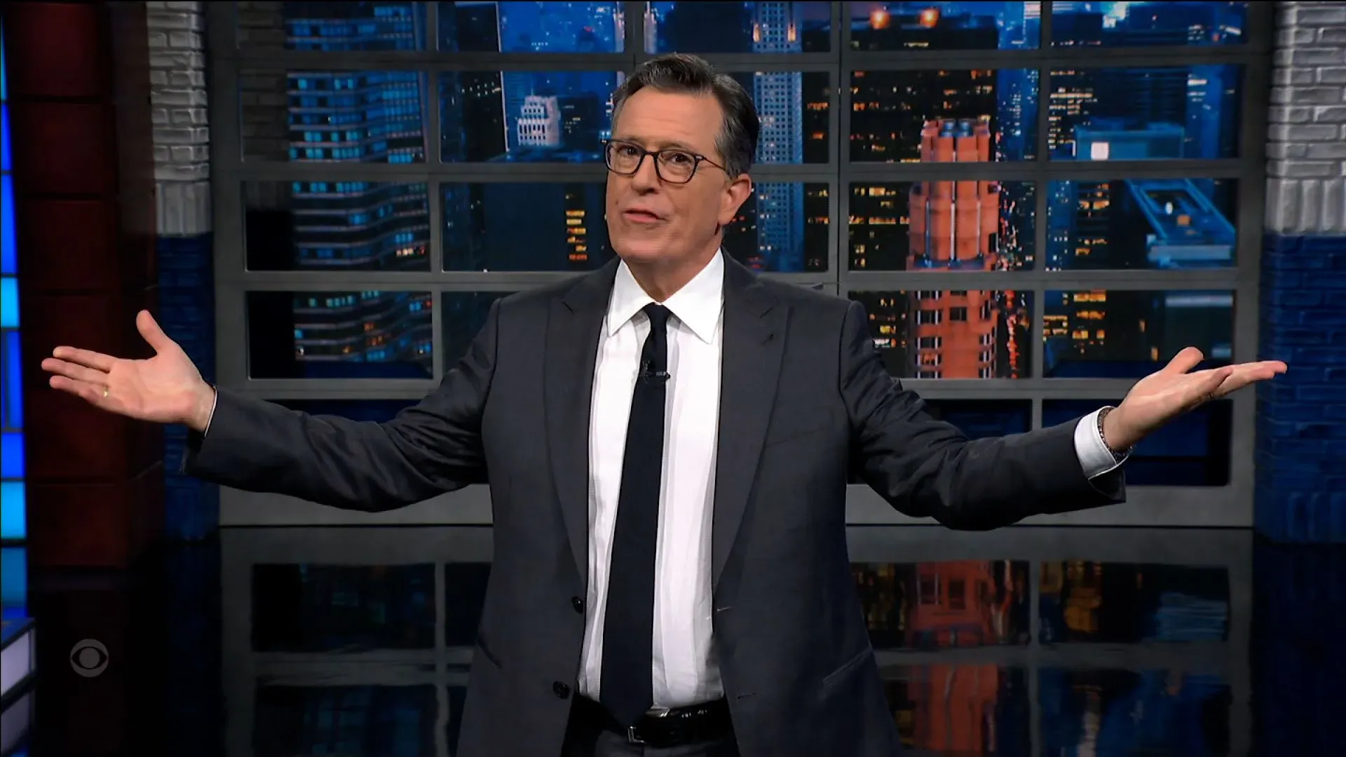 ستيفن كولبير يتحدث على المسرح في برنامج "ذا ليت شو"، مع خلفية لمدينة مضاءة، معبرًا عن مشاعره بعد إعلان إلغاء البرنامج.