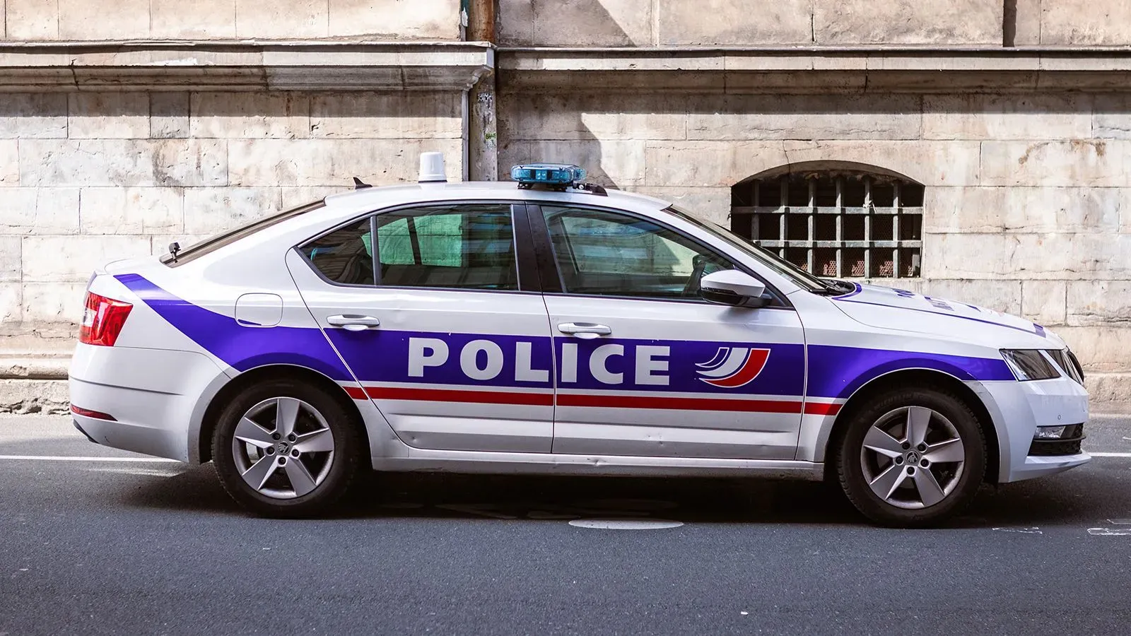 سيارة شرطة فرنسية متوقفة بجانب حائط، تتعلق بقضية مراهقة أمريكية ألقي بطفلها حديث الولادة من نافذة فندق في باريس.