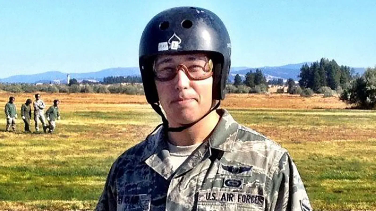 جوزيف سانت كلير، قدامى المحاربين في سلاح الجو الأمريكي، يرتدي خوذة ونظارات في ساحة مفتوحة، وسط خلفية طبيعية.