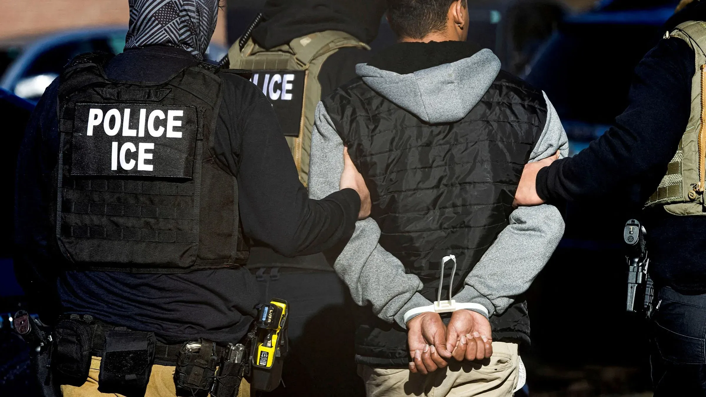 اعتقال شخص من قبل موظفي وكالة إنفاذ قوانين الهجرة والجمارك، مع التركيز على توتر الوضع حول مداهمات الهجرة في لوس أنجلوس.