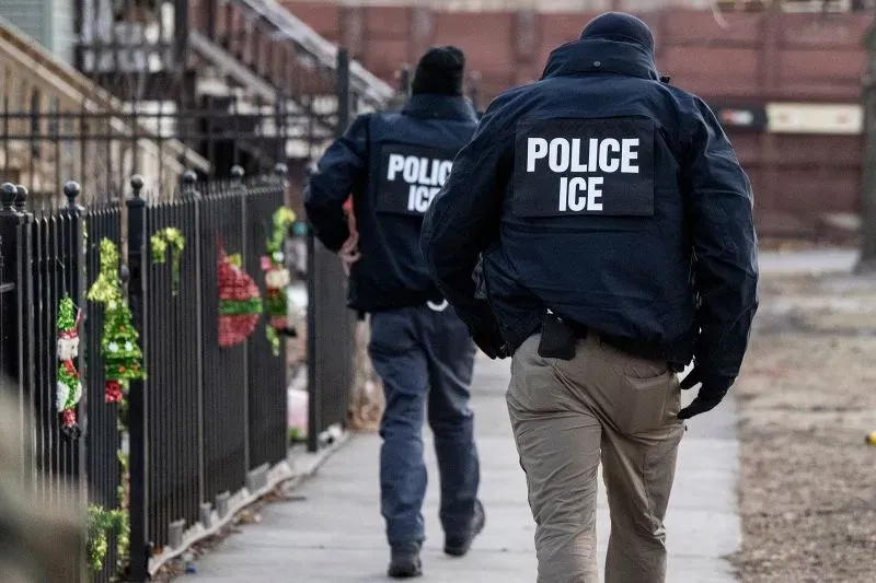 عناصر من إدارة الهجرة والجمارك (ICE) يتجولون في منطقة سكنية، في سياق مناقشات حول سياسات ترامب المتعلقة بالهجرة.