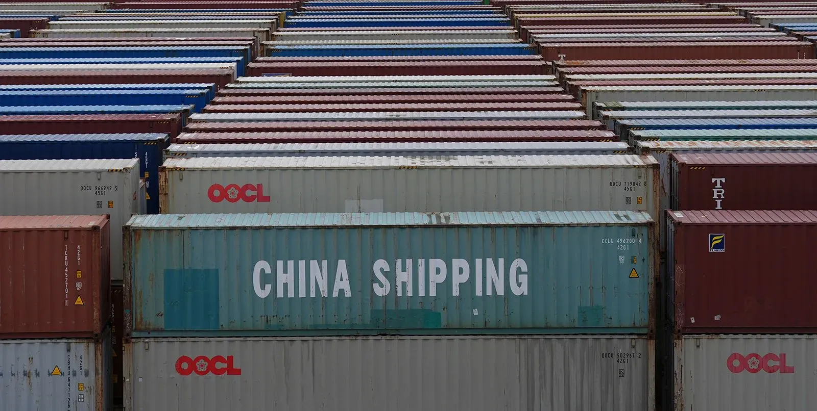 صناديق شحن ملونة تحمل علامة "شحن الصين"، تمثل التجارة العالمية وسط محادثات تجارية بين الولايات المتحدة والصين حول الرسوم الجمركية.