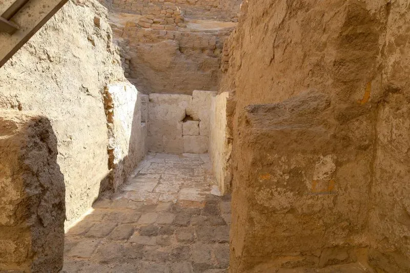 ممر ضخم داخل مقبرة قديمة في أبيدوس، يظهر جدران الحجر الجيري المدعمة، مما يبرز الأهمية التاريخية للاكتشاف.