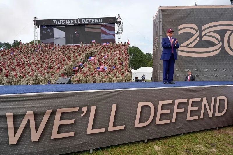 احتفال بالذكرى الـ250 للجيش الأمريكي، مع الرئيس ترامب يتحدث أمام جنود يرتدون الزي العسكري، بينما يحمل البعض الأعلام.