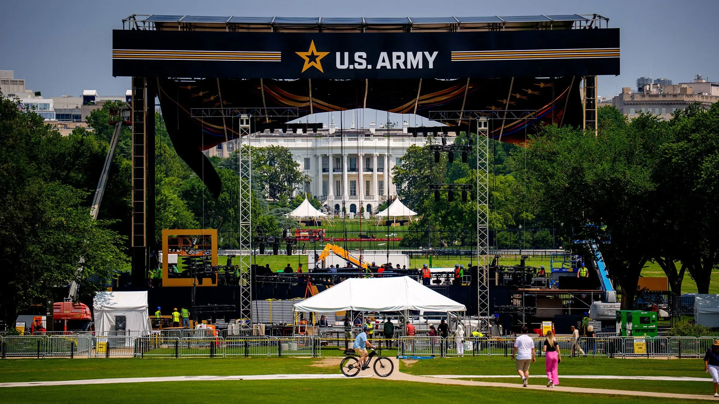 استعدادات للاحتفال بعيد ميلاد الجيش الأمريكي الـ250 في واشنطن، مع منصة كبيرة تحمل شعار "U.S. ARMY" خلفها البيت الأبيض.