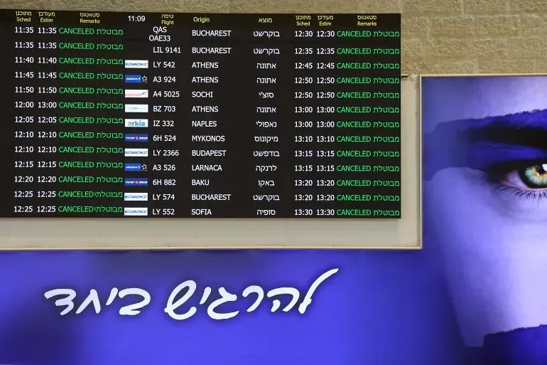 تظهر لوحة معلومات في مطار تحتوي على تفاصيل رحلات ملغاة، مما يعكس تأثير الصراع الإقليمي على حركة الطيران.