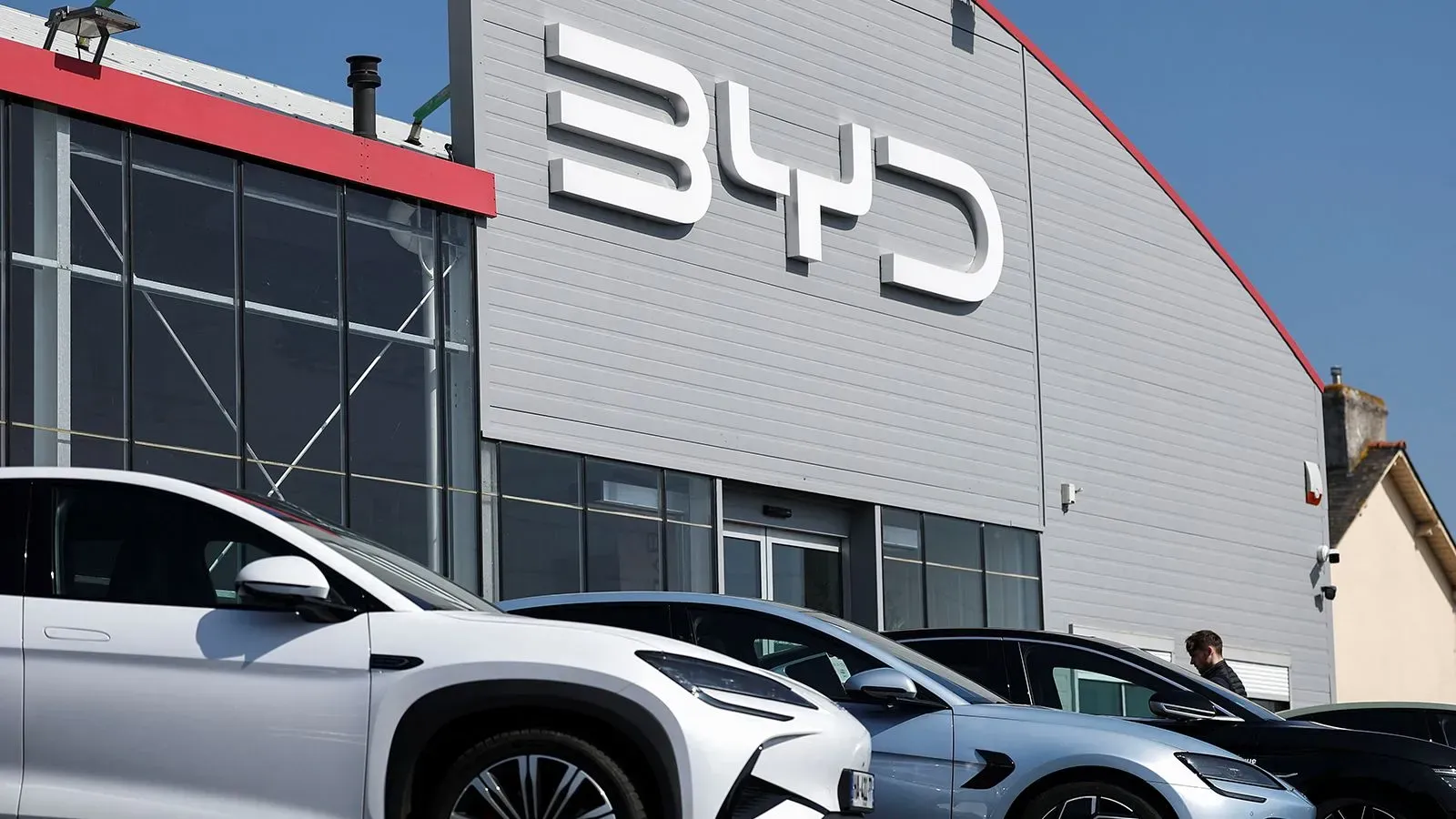 واجهة شركة BYD مع سيارات كهربائية أمامها، تعكس نجاح الشركة في زيادة المبيعات والتوسع في الأسواق العالمية.