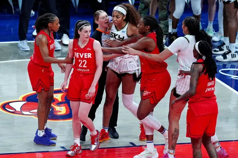 تظهر الصورة مشادة بين لاعبات فريقي إنديانا فيفر وشيكاغو سكاي، حيث تتوسط كايتلين كلارك وأنجيل ريس في لحظة توتر خلال المباراة.