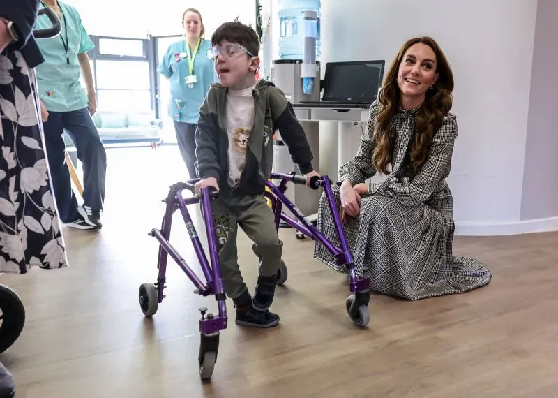 زيارة كاثرين أميرة ويلز إلى دار رعاية الأطفال "تيك هافان"، حيث تتفاعل مع طفل يستخدم مشاية، مبينة دعمها للأطفال ذوي الحالات المرضية.