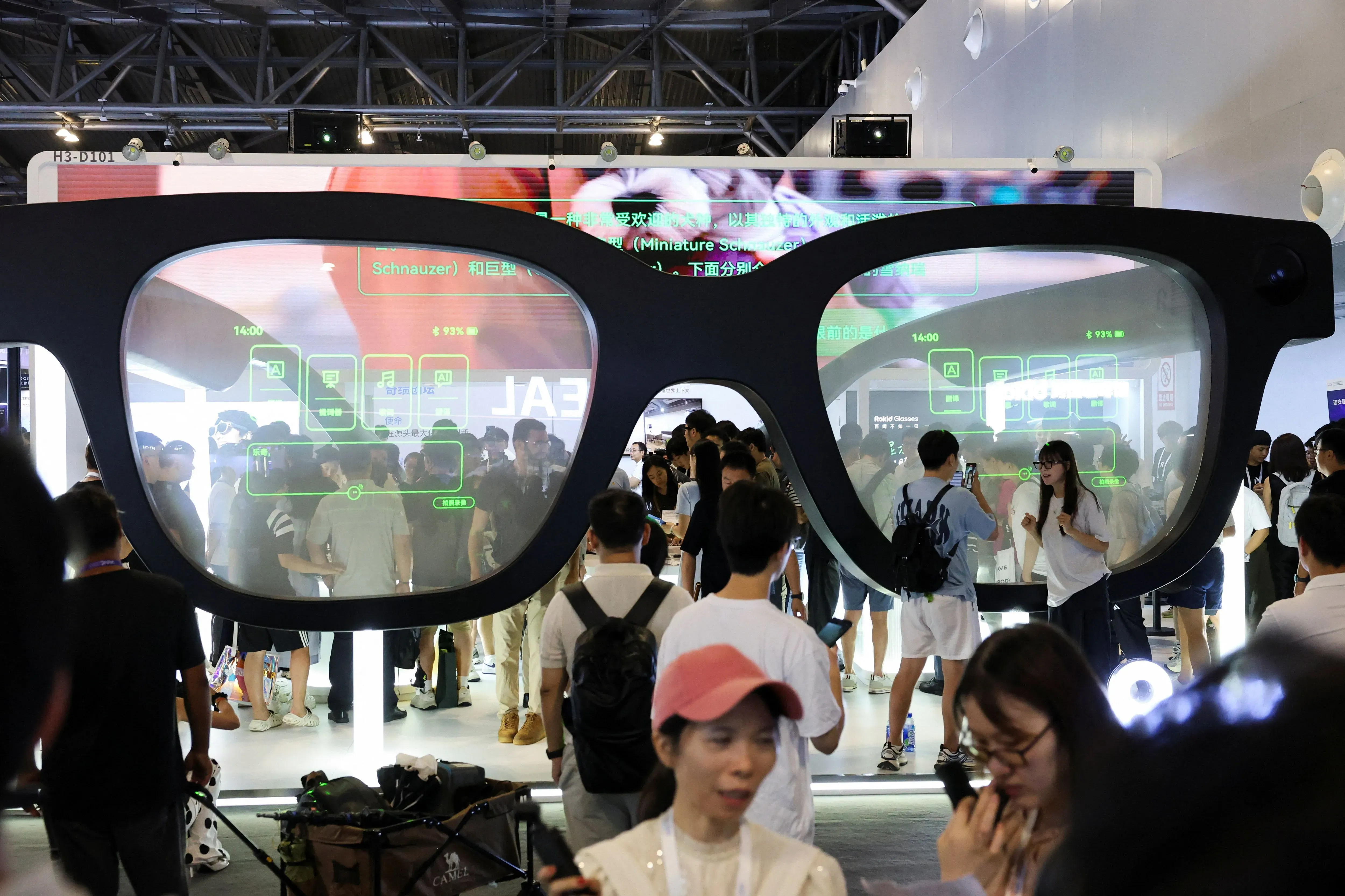 نظارات ضخمة تعرض تقنيات الذكاء الاصطناعي خلال المؤتمر العالمي للذكاء الاصطناعي في شنغهاي، مع حشد من الزوار يتفاعلون مع التكنولوجيا.