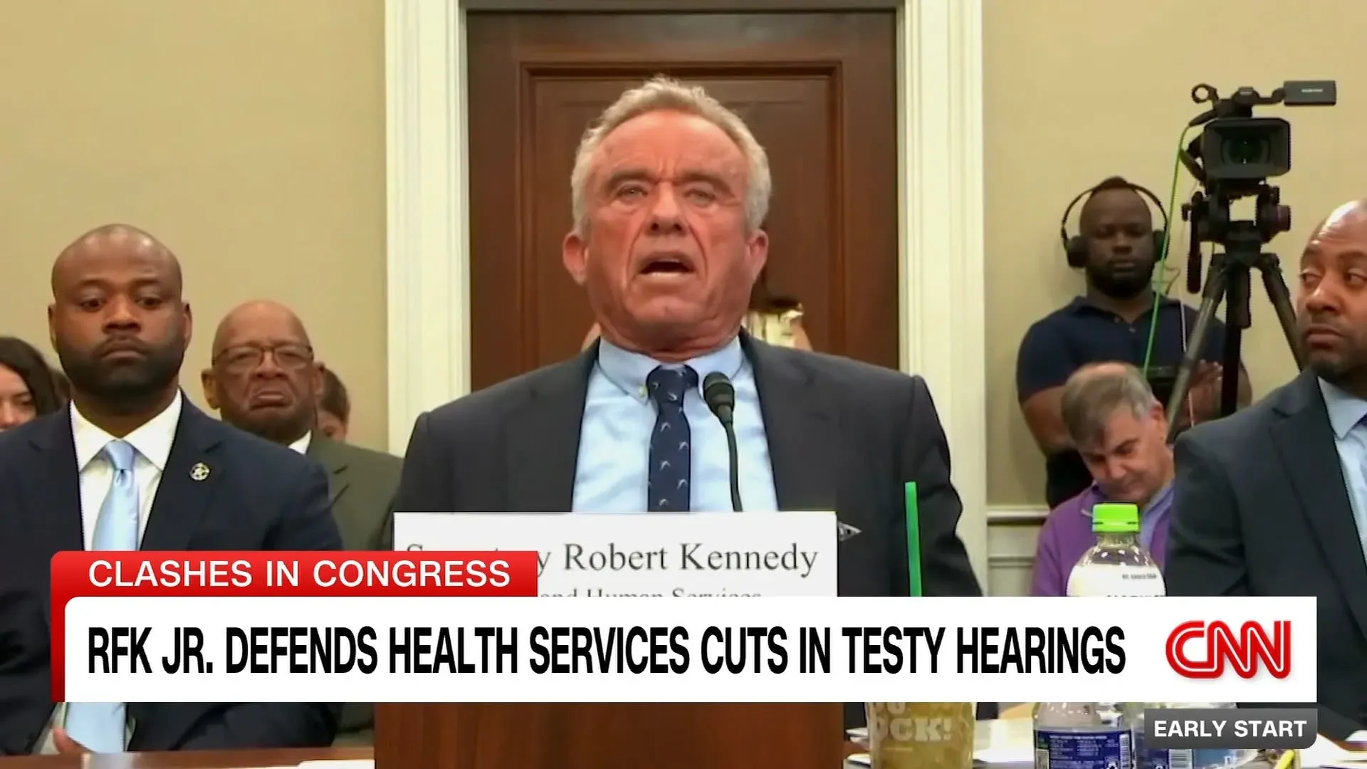 روبرت كينيدي جونيور يتحدث في جلسة استماع أمام الكونغرس، مدافعًا عن تخفيضات خدمات الصحة، بينما يستمع الحضور بتركيز.