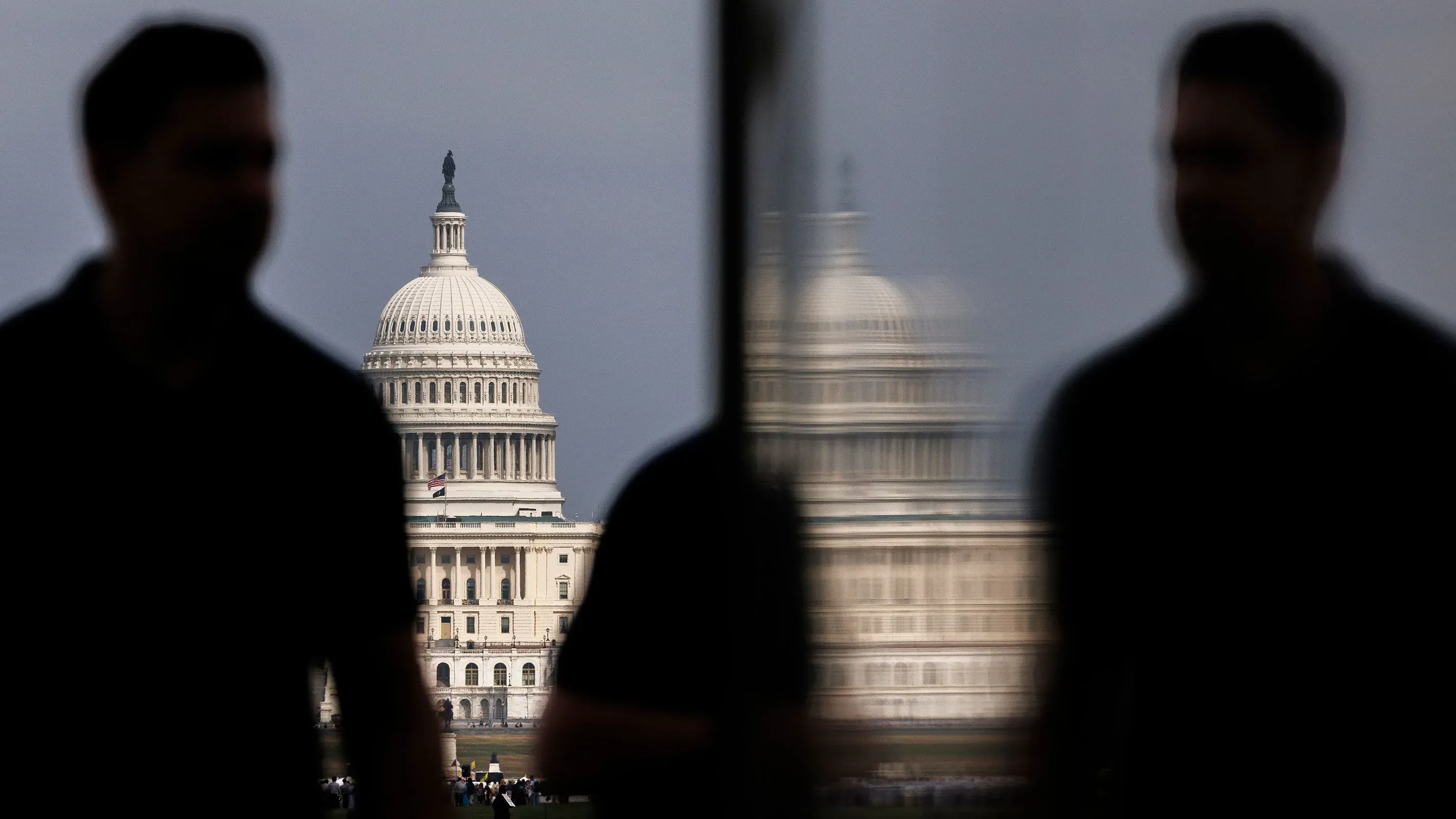 صورة توضح مبنى الكابيتول الأمريكي مع silhouettes لأشخاص في المقدمة، تعكس التوترات السياسية التي يواجهها الديمقراطيون في انتخابات مجلس الشيوخ.