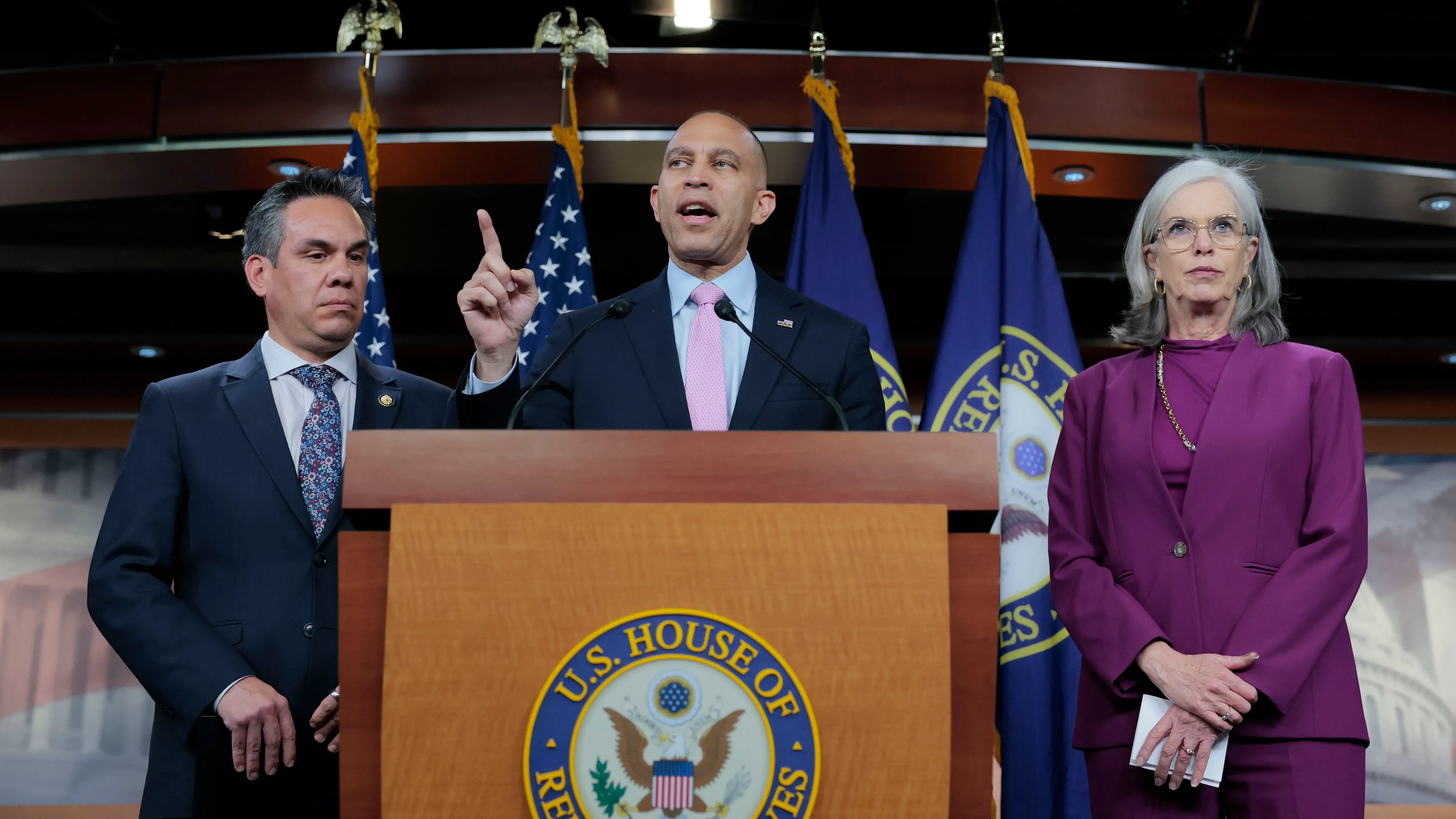 اجتماع لقادة الحزب الديمقراطي في واشنطن، يتحدث أحدهم أمام ميكروفون، مع أعلام خلفهم، في سياق مناقشة مشروع قانون تمويل الحكومة.