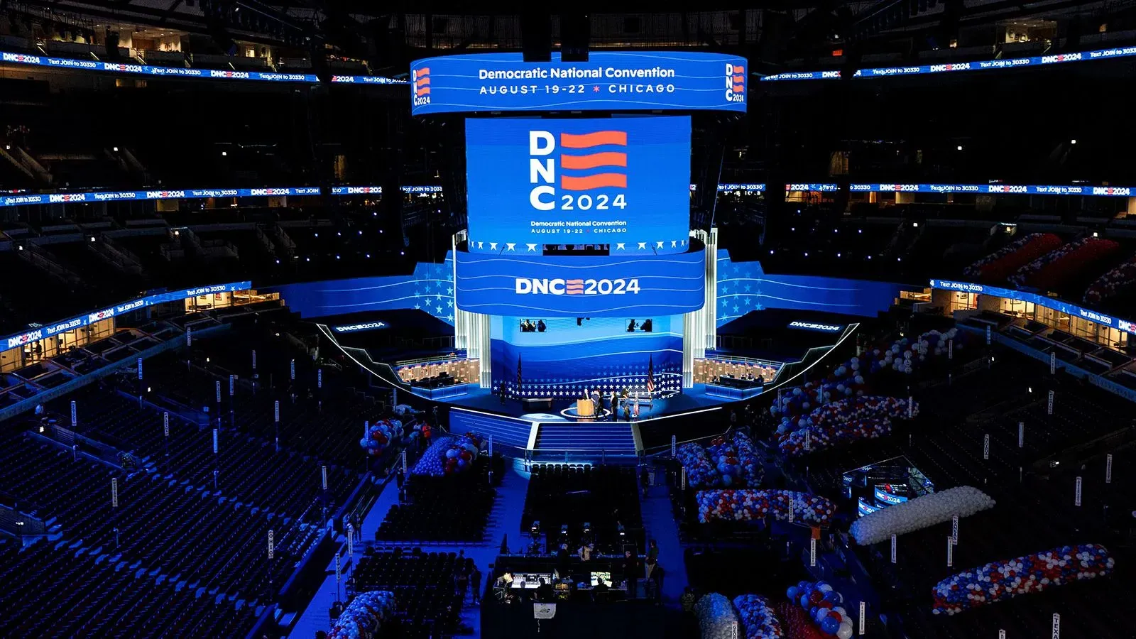 ساحة المؤتمر الوطني الديمقراطي 2024 في شيكاغو، مع لافتات كبيرة تحمل شعار DNC 2024، وأجواء مهيبة تستعد لاستقبال المشاركين.
