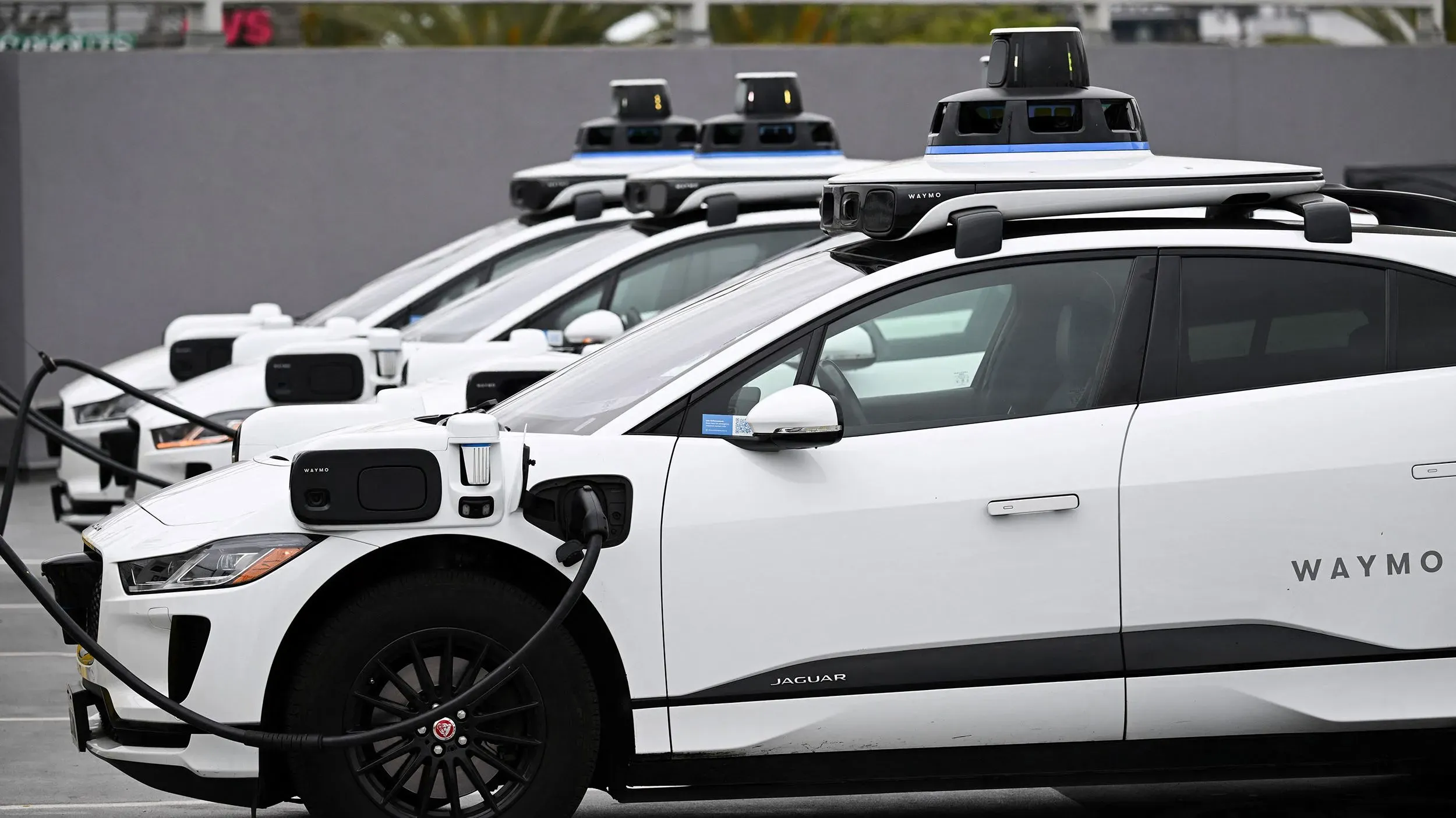 سيارات وايمو ذاتية القيادة من طراز جاكوار I-PACE، متوقفة في صف، مع وجود معدات تكنولوجية على السقف، تشير إلى الابتكار في النقل.