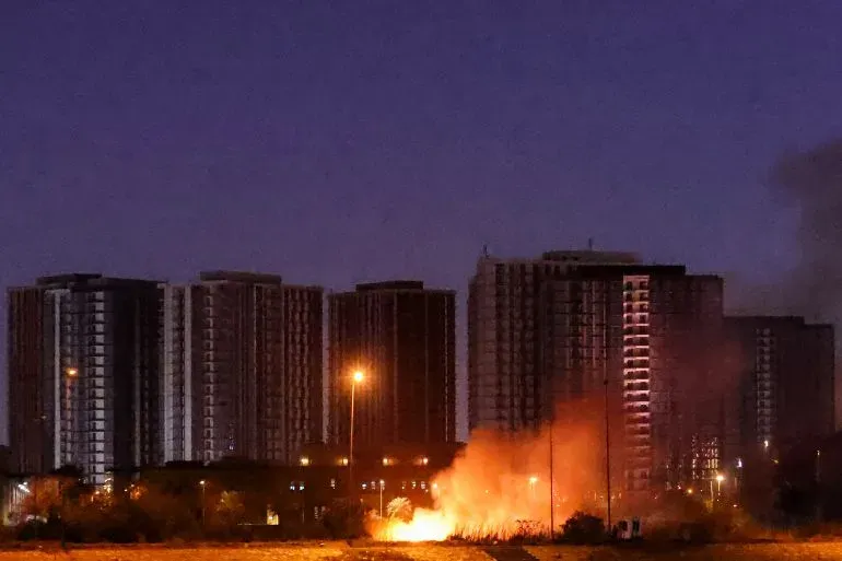 انفجار يضيء سماء بغداد ليلاً، مع ظهور مباني شاهقة في الخلفية، في سياق هجوم بطائرة مسيرة على مقر جهاز المخابرات الوطني.