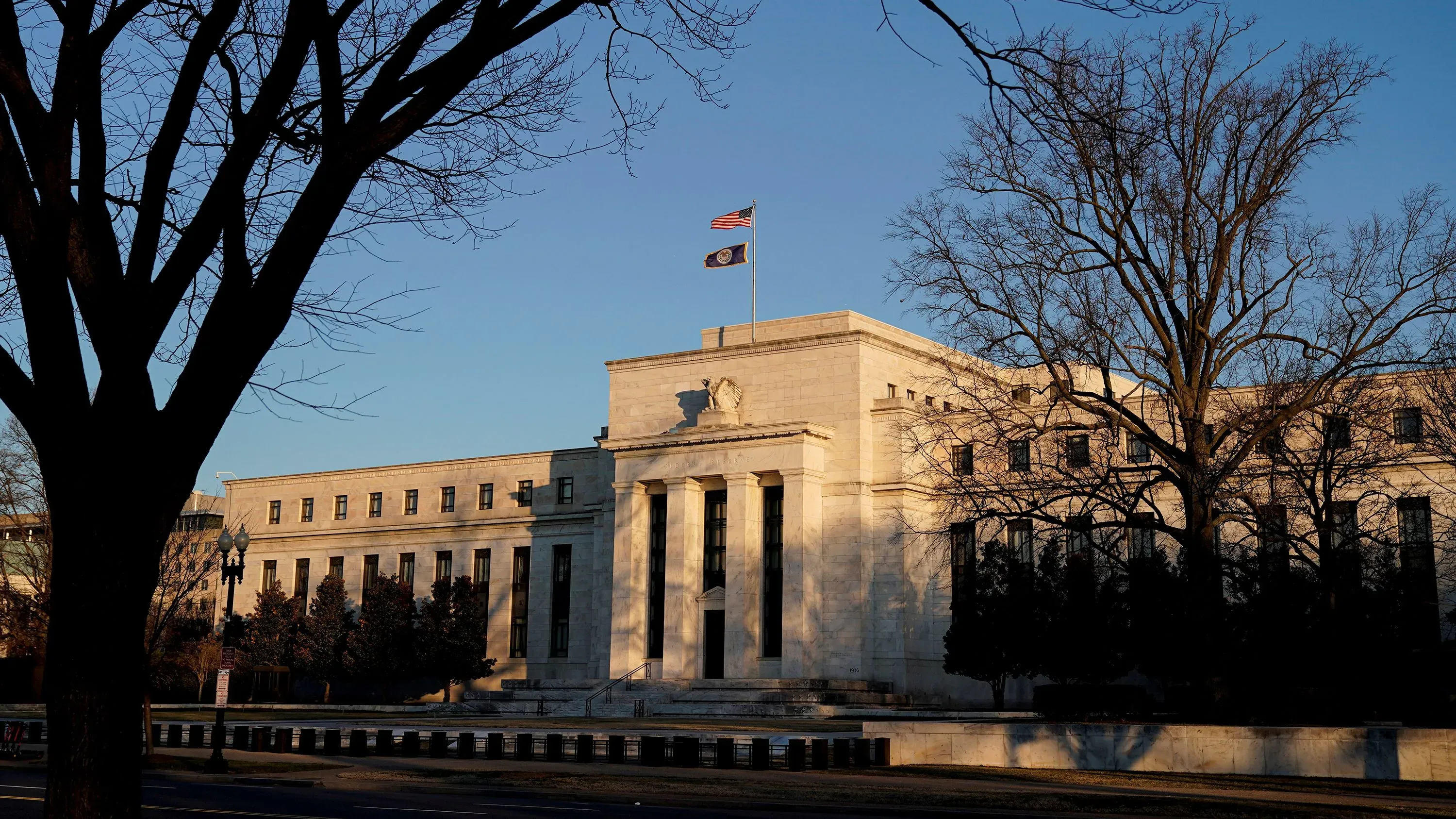 مبنى الاحتياطي الفيدرالي في واشنطن، يظهر العلم الأمريكي، مع التركيز على أهمية استقلالية البنك المركزي في السياسة النقدية.