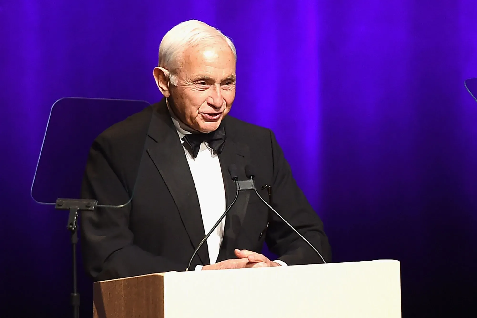 نائب جمهوري يتحدث في حدث رسمي، مع خلفية مضيئة، حيث يسلط الضوء على قضايا تتعلق بالتحقيقات في الاتجار بالجنس.