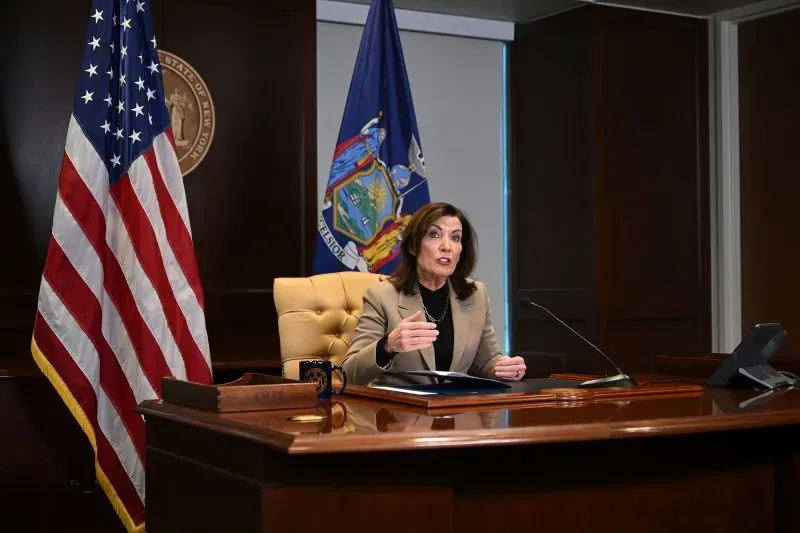 كاثي هوخول، الحاكمة الديمقراطية، تتحدث من مكتبها، مع العلم الأمريكي خلفها، أثناء مناقشة قضية إريك آدامز.