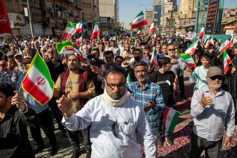 مظاهرة حاشدة في إيران، حيث يحمل المتظاهرون الأعلام الإيرانية ويعبرون عن دعمهم في مواجهة التوترات الإقليمية مع إسرائيل.