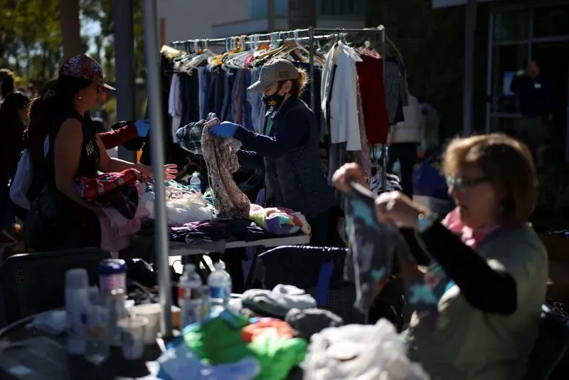 متطوعون في لوس أنجلوس يرتبون الملابس في موقع جمع التبرعات لدعم ضحايا الحرائق، ويظهرون التكاتف المجتمعي في مواجهة الكارثة.