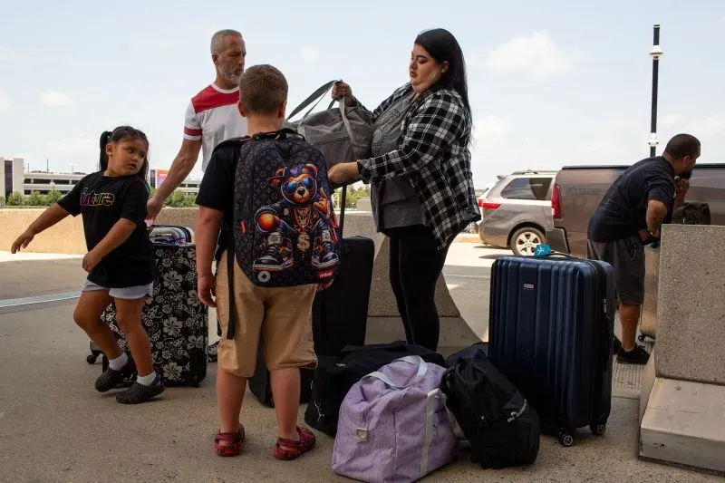 عائلة تتكون من خمسة أفراد، تشمل أطفالًا، تقوم بتحميل الأمتعة في مطار، استعدادًا لمغادرة الولايات المتحدة إلى المكسيك.