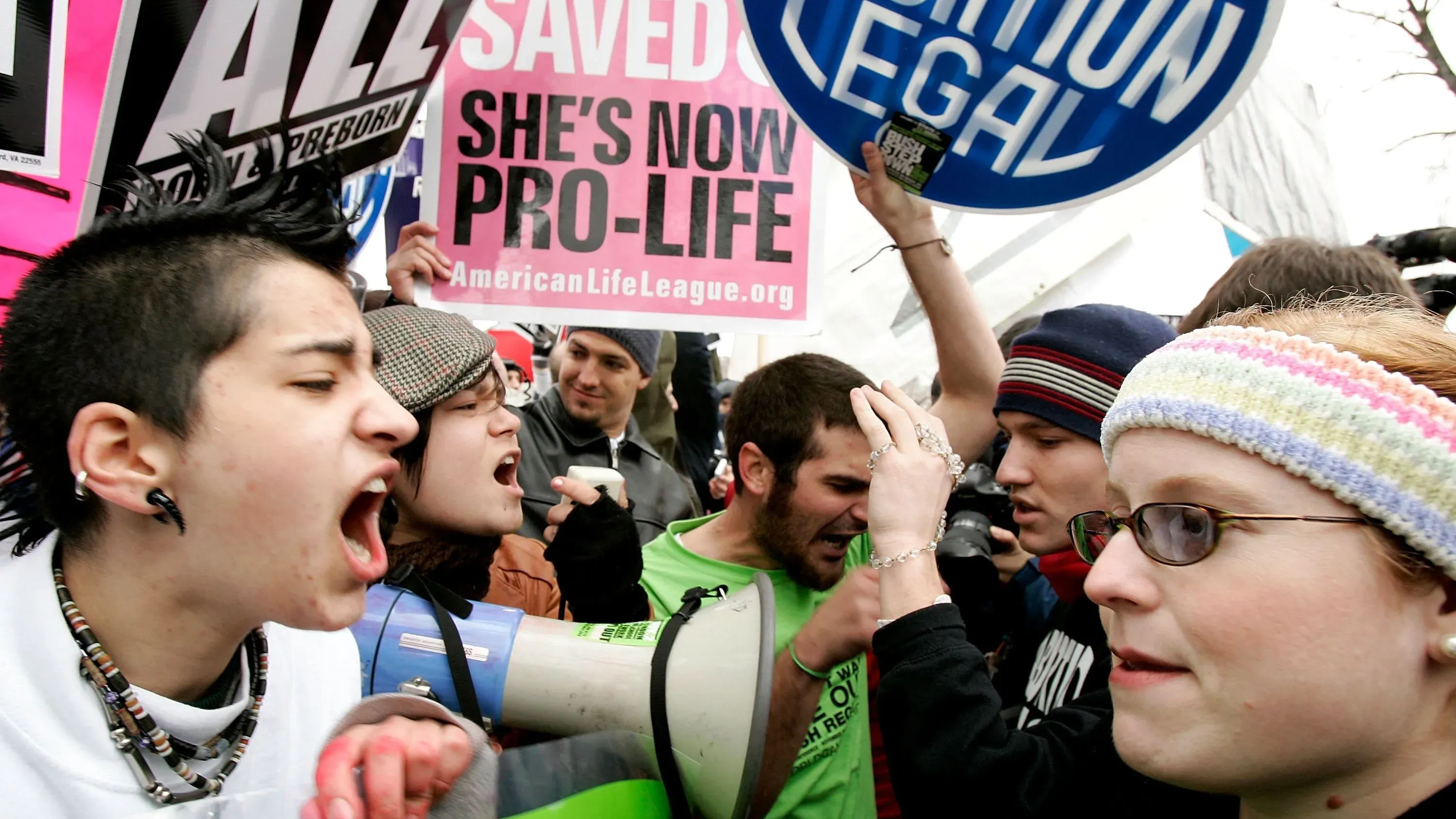 مظاهرة حاشدة حول حقوق الإجهاض، حيث يتجمع مؤيدو ومعارضو الإجهاض، مع لافتات تعبر عن آراء متباينة.