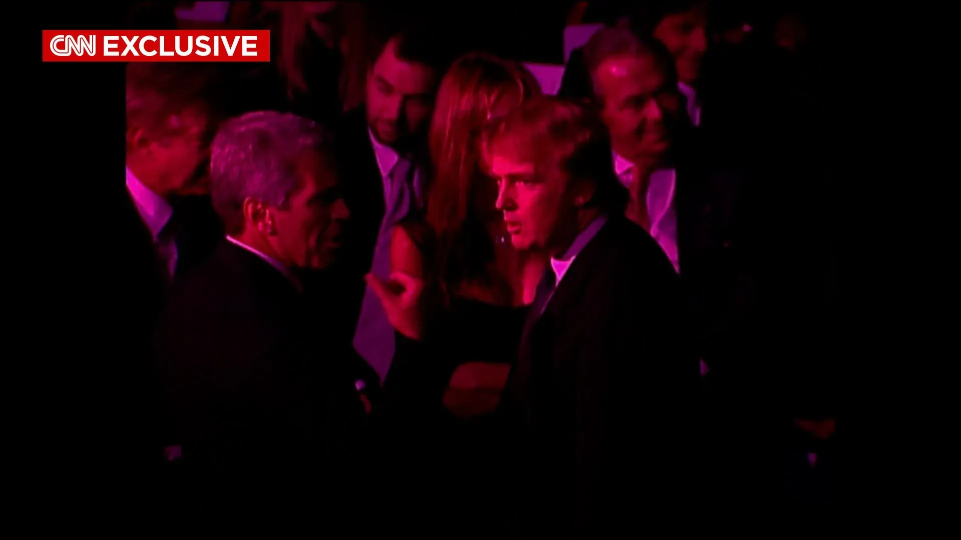 لقطة من عرض أزياء فيكتوريا سيكريت عام 1999 تُظهر دونالد ترامب وجيفري إبشتاين يتحدثان معًا في أجواء احتفالية.