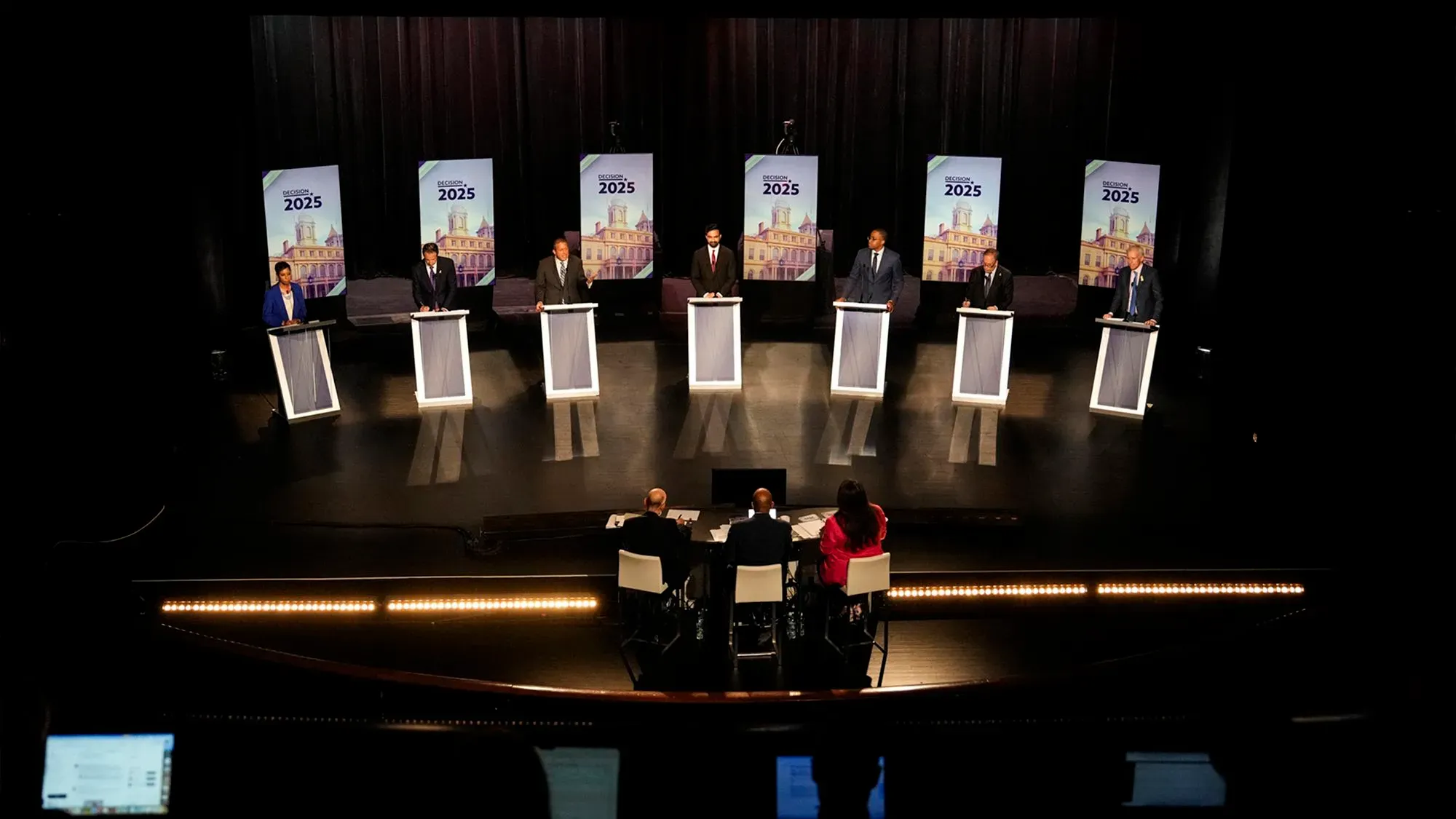 مناظرة انتخابية لمرشحي الحزب الديمقراطي لمنصب عمدة نيويورك، مع وجود لوحات تحمل شعار الانتخابات لعام 2025.