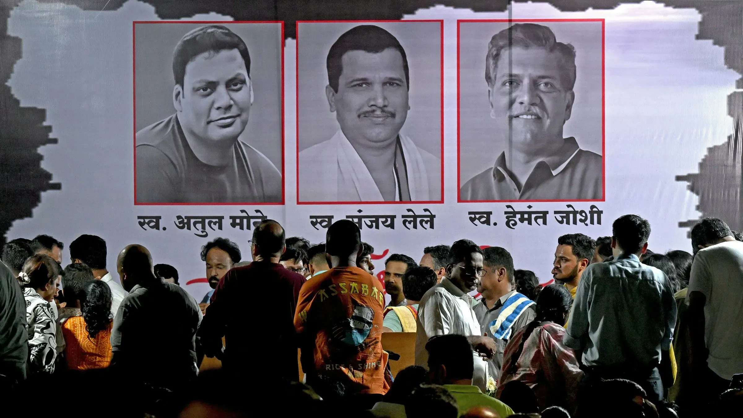 تجمع حشد من الناس في حدث تأبيني، مع صور لثلاثة ضحايا من حادث مروع في كشمير، يعكس الحزن والتضامن في مواجهة العنف.