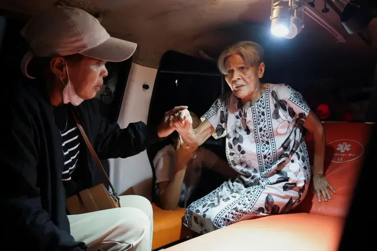 امرأة مسنّة تتلقى المساعدة في سيارة إسعاف بعد حريق مميت في دار لرعاية المسنين في إندونيسيا، حيث أسفر الحريق عن 16 وفاة.