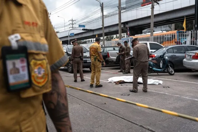 موقع الحادث في بانكوك حيث يعمل رجال الشرطة على التحقيق في إطلاق نار أدى لمقتل خمسة أشخاص، مع وجود جثة مغطاة.