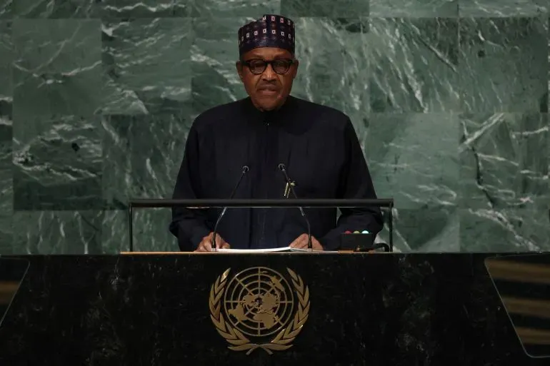 الرئيس النيجيري السابق محمد بخاري يتحدث أمام منصة الأمم المتحدة، مع خلفية من الحجر الأخضر، في مناسبة رسمية.