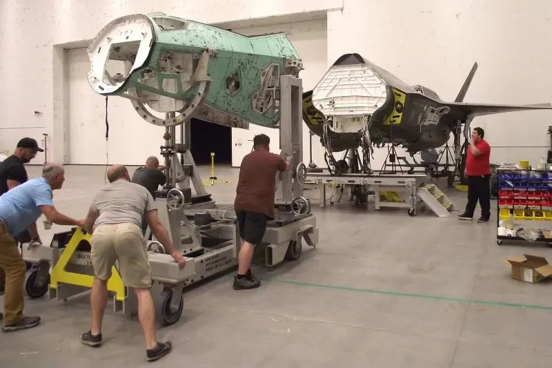 فريق من المهندسين يقومون بتجميع أجزاء الطائرة "فرانكنجيت" من طائرتين F-35 معطلتين، في ورشة عمل مخصصة للصيانة.