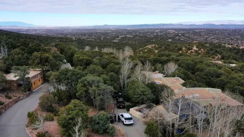 منظر جوي لمنزل جين هاكمان وزوجته بيتسي أراكاوا في سانتا في، مع وجود سيارات للشرطة في الموقع، مما يشير إلى تحقيقات حول وفاتهما.