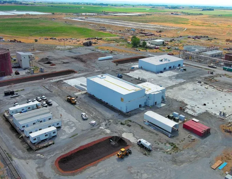 منشأة بحثية لتطوير وقود الطائرات المستدام، تظهر المباني والمعدات في موقع واسع مع مساحات خضراء في الخلفية.