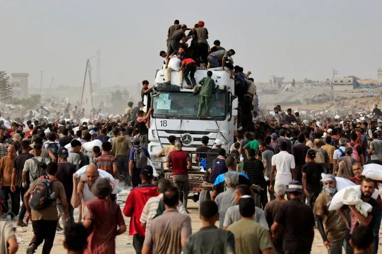 حشود كبيرة من الفلسطينيين يتجمعون حول شاحنة إغاثة في غزة، وسط أزمة إنسانية متفاقمة بسبب الحصار والقتال.