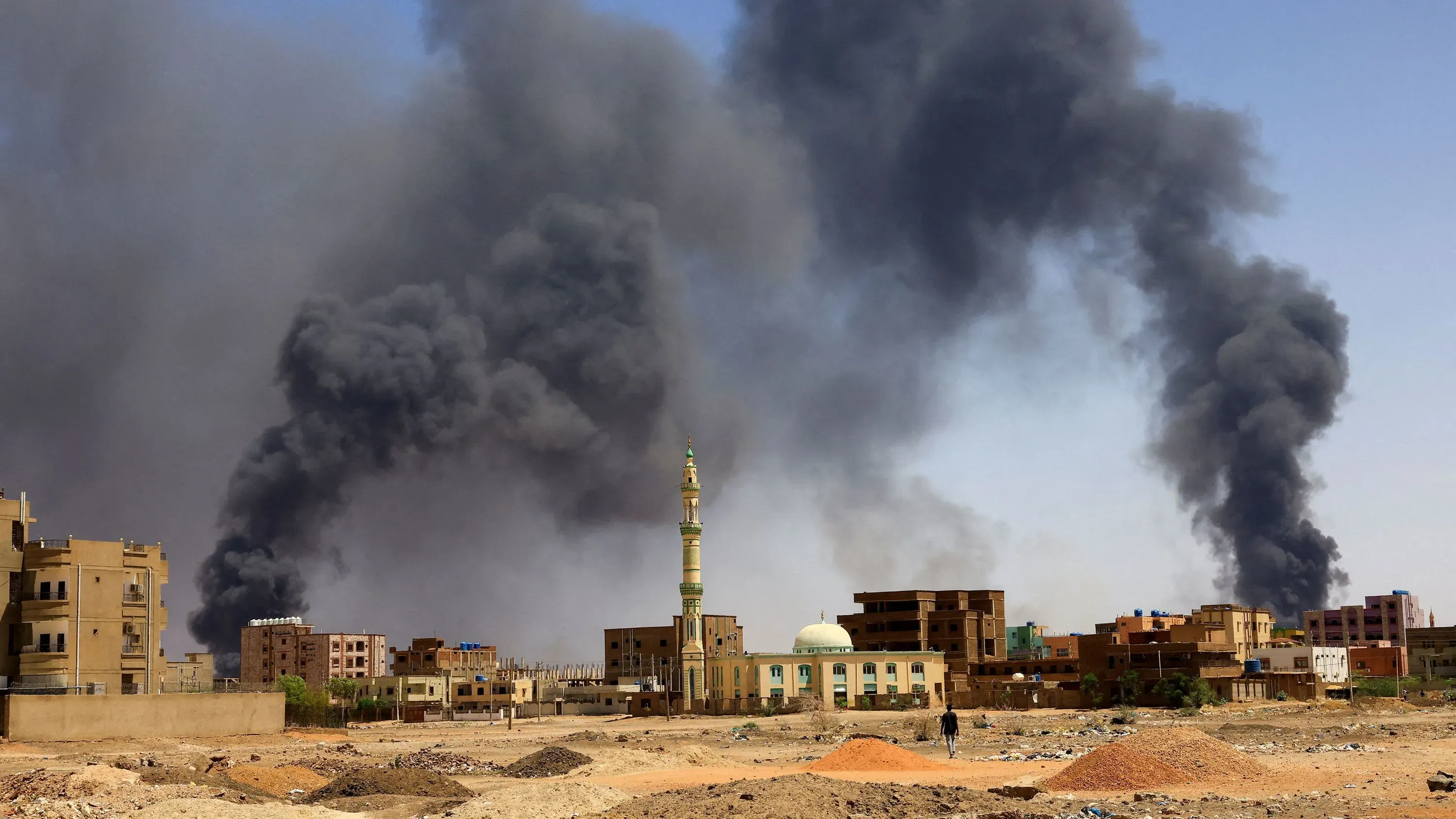 دخان كثيف يتصاعد من المباني في الخرطوم، مما يعكس آثار الصراع الأهلي في السودان وتأثيره المدمر على المدنيين.