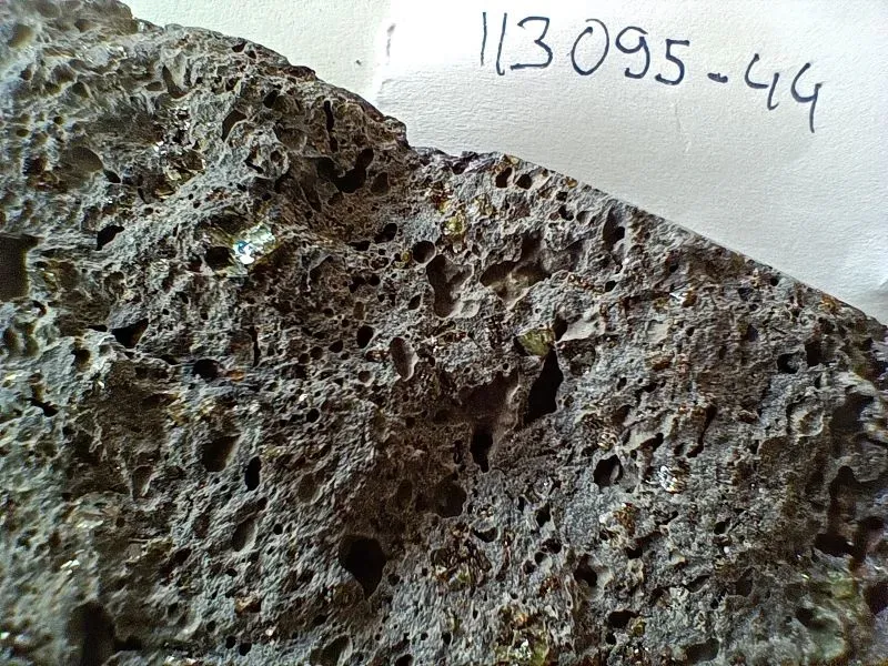 صورة لصخرة بازلتية تظهر تفاصيل مسامية، تشير إلى المعادن الثمينة التي تسربت من لب الأرض إلى السطح، كما هو موضح في دراسة حول تكوين الجزر البركانية.