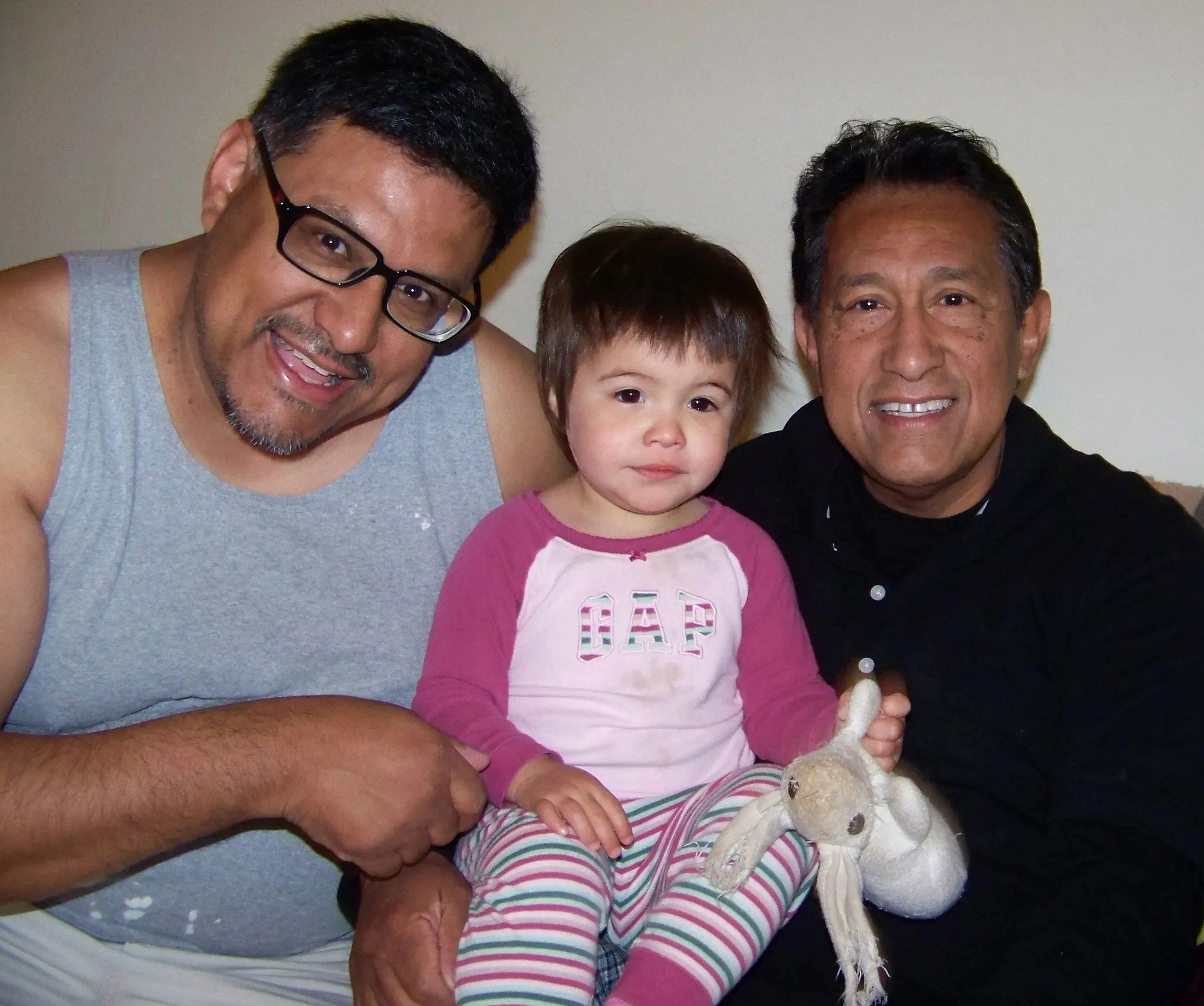 لقطة عائلية لجوزيف لويا مع ابنته ووالده، حيث يظهر الثلاثة مبتسمين، مما يعكس لحظات من السعادة والتواصل العائلي بعد ماضيه الإجرامي.