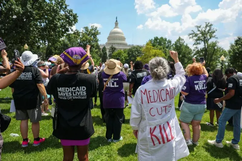 تجمع حشود أمام الكابيتول هيل للاحتجاج على تخفيضات برنامج Medicaid، مع شعارات تدعو للحفاظ على الرعاية الصحية.
