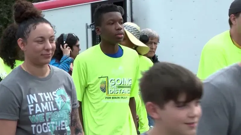 شباب يرتدون قمصان صفراء زاهية خلال فعالية لدعم المصابين بإصابات الدماغ، مع التركيز على روح التضامن والمشاركة المجتمعية.