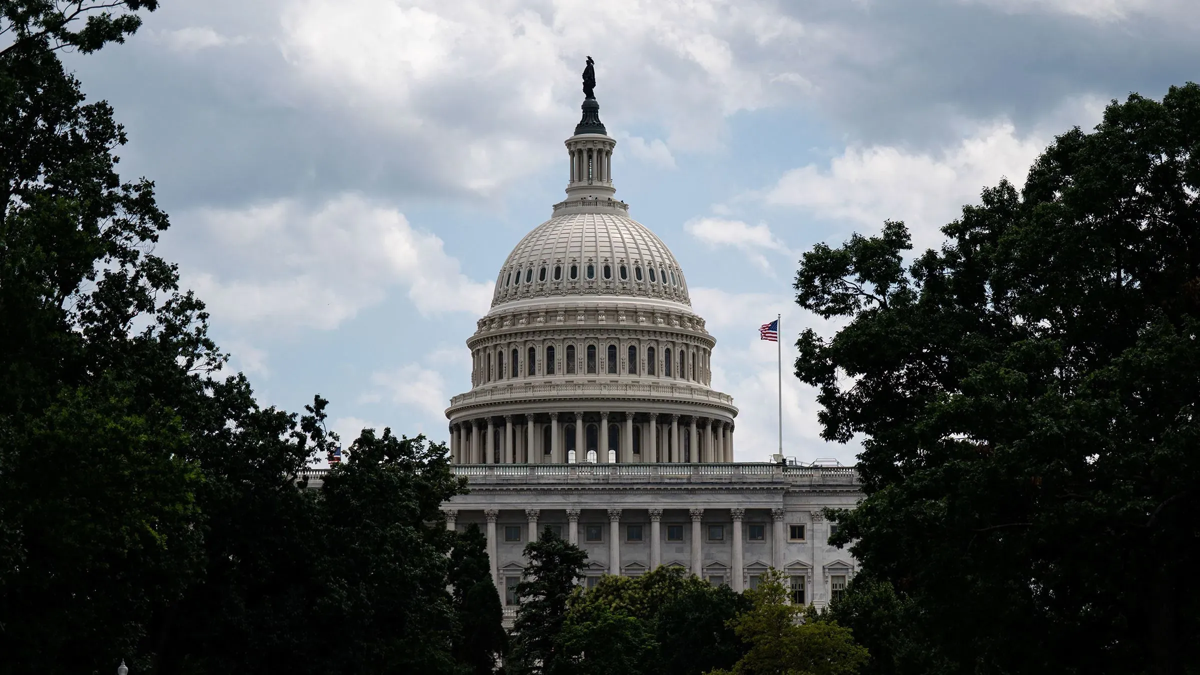 قبة مبنى الكابيتول الأمريكي محاطة بالأشجار، تحت سماء ملبدة بالغيوم، في سياق تصويت الكونغرس على تخفيضات الإنفاق.