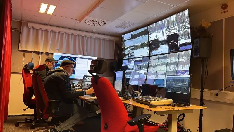 غرفة التحكم في برنامج "هجرة الموظ العظيمة" مع طاقم العمل يراقبون البث المباشر عبر شاشات متعددة، مما يعكس اهتمامهم بتوثيق الهجرة الطبيعية.