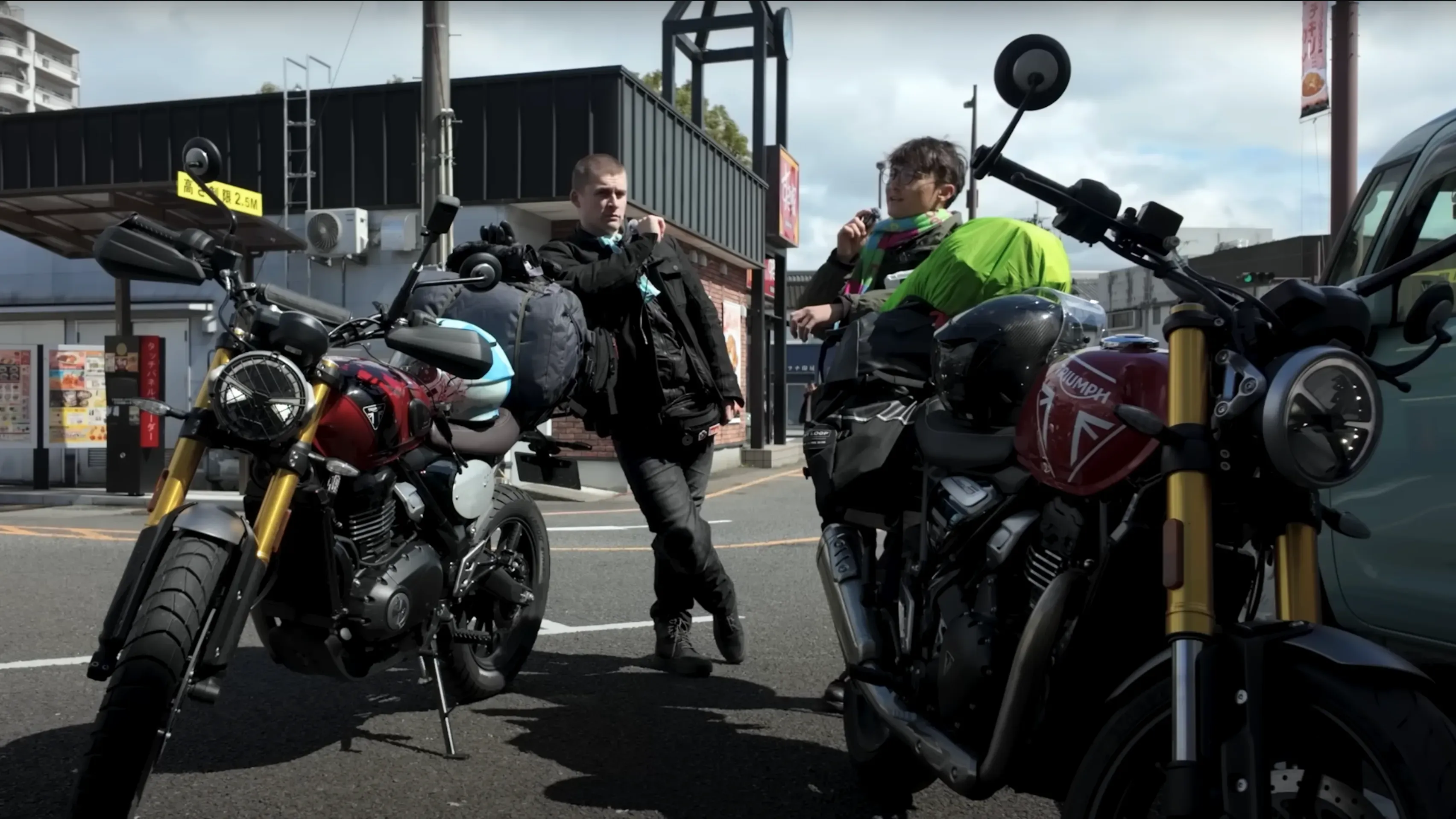 شخصان يستعدان للانطلاق على دراجتين ناريتين في اليابان، مع حقائب على الدراجات، في خلفية حضرية تعكس روح المغامرة.